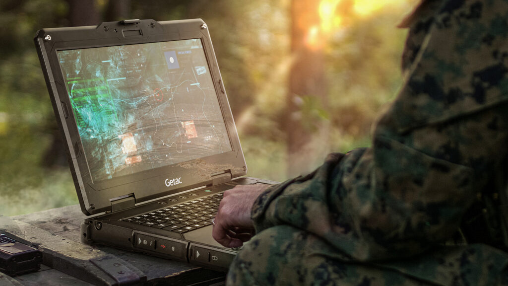 Military worker checking plans on laptop