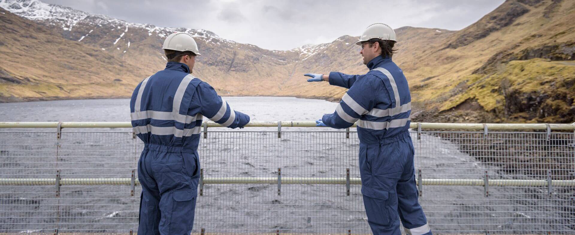 Workers talking about work on the bridge over the lake