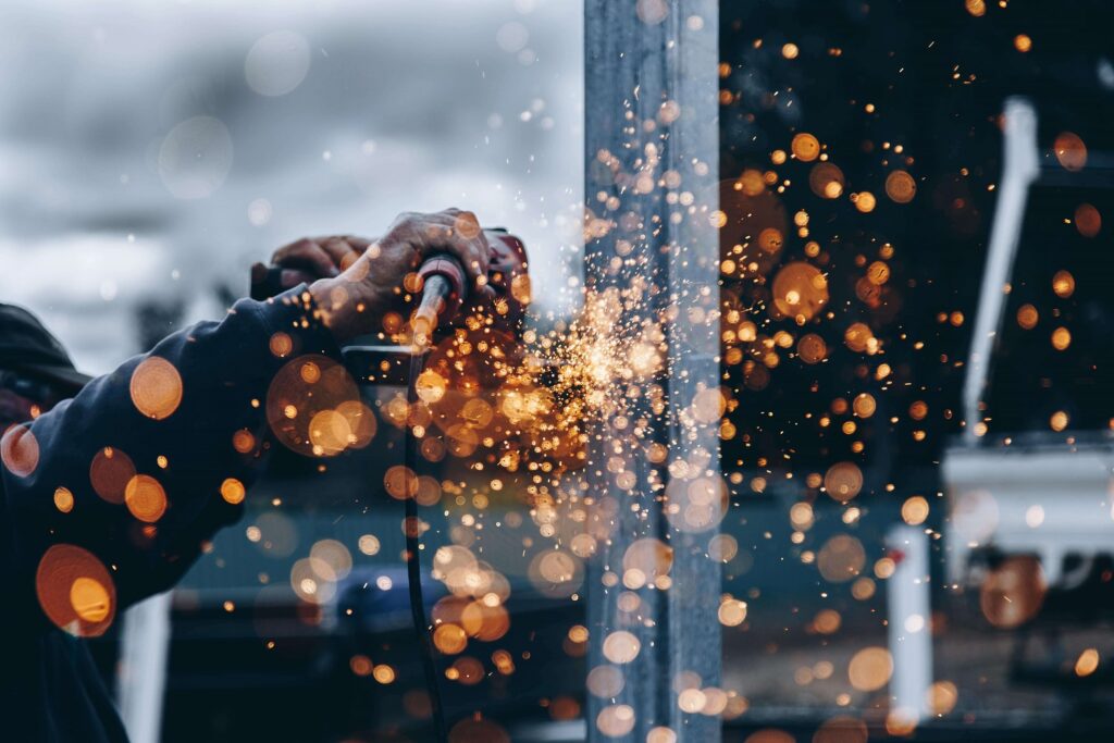 The saw cuts a metal frame with flying sparks