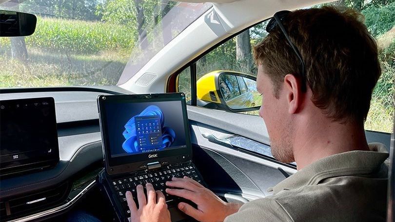 A man in a car with a laptop