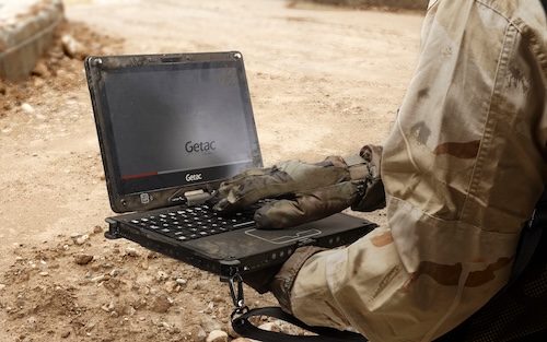 Military worker holds an open laptop